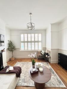 a living room with a couch and a table at Modern Spacious 4 Bedroom Home in Greater LDN With Garden and Parking in Dartford