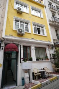 a yellow and white building with chairs in front of it at BDK hotel in Istanbul