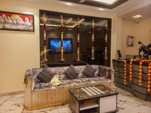 a living room with a couch and a tv at Omkar Hotel - Mahabaleshwar in Panchgani