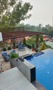 a backyard with a swimming pool and a wooden fence at Omkar Hotel - Mahabaleshwar in Panchgani