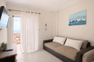 a living room with a couch and a window at Rona Vista Suites amazing seaview 3 in Polychrono