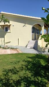 a house with a lawn in front of it at Villa Penelia next to golf courses in Romanu
