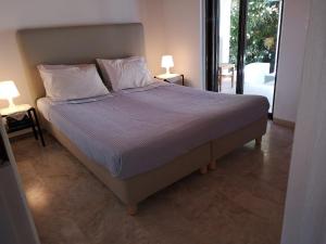 a large bed in a bedroom with two lamps on tables at Villa Penelia next to golf courses in Romanu +43 photos