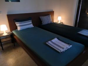 a bedroom with two beds with blue sheets and two lamps at Villa Penelia next to golf courses in Romanu