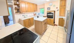 a kitchen with wooden cabinets and a black appliance at Roslyn in Romsey
