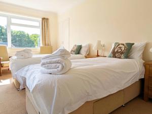 a bedroom with two beds with towels on them at Roslyn in Romsey
