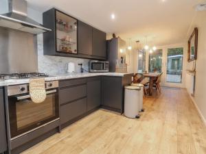 a kitchen with stainless steel appliances and a wooden floor at Thieveley Pike View in Burnley