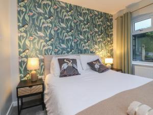 a bedroom with a bed with a floral wallpaper at Thieveley Pike View in Burnley