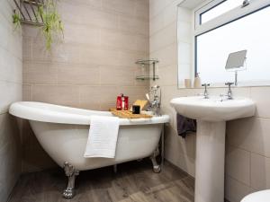 a bathroom with a white tub and a sink at Thieveley Pike View in Burnley +27 photos