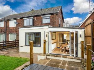 a extension to a brick house with sliding glass doors at Thieveley Pike View in Burnley