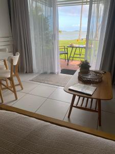 a living room with a table and a view of the ocean at Lousha Bach Dolphin Heads in Eimeo +7 photos