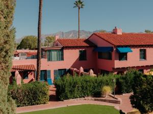 a red house with a palm tree and a yard at Arizona Inn in Tucson