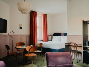 a hotel room with a bed and a table and chairs at The Dean Berlin in Berlin