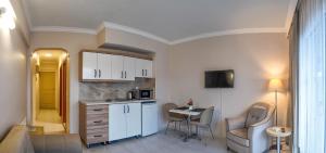 a kitchen with white cabinets and a table and chairs at Asya Blue Apartments in Marmaris