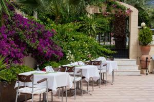 a row of tables and chairs with purple flowers at Asya Blue Apartments in Marmaris