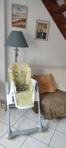 a chair in a room with a lamp and a bed at La Maisonnette in Calais