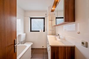 a bathroom with a sink and a tub and a toilet at KS01 Monteurwohnung mit Ausblick! in Alsbach-Hähnlein +4 photos
