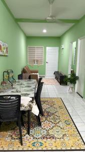 a living room with a table and a couch at Al-Hijrah Homestay Meru Klang in Kapar
