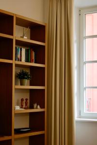 a book shelf with a window and a curtain at Piazza del Lago Suites - Menaggio in Menaggio