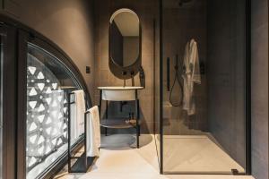 a bathroom with a shower with a chair and a mirror at Lenel Boutique Room - La Locanda in Brescia