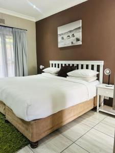 a bedroom with a large bed with white sheets at ZQ Guest House in Mthatha
