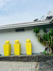 a building with yellow pillars with oranges on it at ZQ Guest House in Mthatha