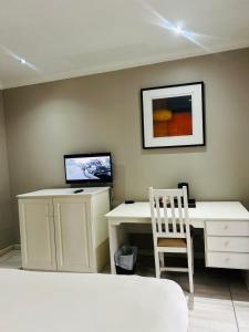 a desk with a computer and a chair in a room at ZQ Guest House in Mthatha