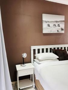 a bedroom with two beds and a night stand with a lamp at ZQ Guest House in Mthatha