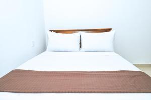 a bed in a room with two pillows at Rika Guest House in Kokkuvil East
