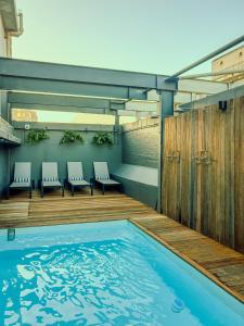 a swimming pool with chairs and a wooden deck at Old Bank Hotel - Lion Roars Hotels & Lodges in Cape Town