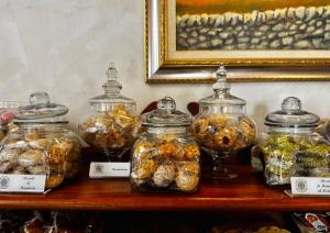 a shelf with glass jars filled with different types of food at Hotel Il Barocco in Ragusa