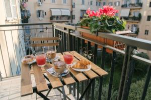 - une table en bois avec de la nourriture et des boissons sur un balcon dans l'établissement Vatican Garden Rooms, à Rome