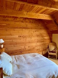 a bedroom with a bed and a wooden wall at Grange Mary in Le Falgoux
