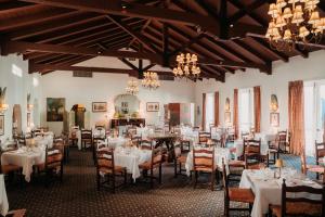 a dining room with tables and chairs and chandeliers at Arizona Inn in Tucson