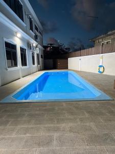 a blue swimming pool in front of a house at night at Villa Mauritius in Albion