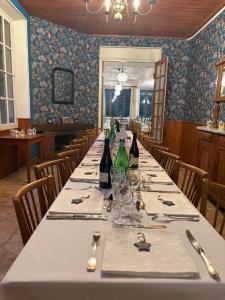 a long table in a restaurant with wine bottles at Chalet Hotel d Ailefroide in Ailefroide +5 photos