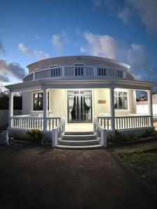 a large white house with a porch and stairs at Villa Mauritius in Albion