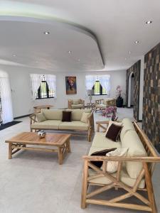 a living room with couches and tables and windows at Villa Mauritius in Albion