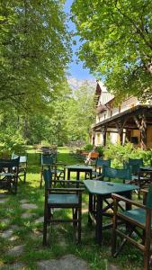 a group of picnic tables and chairs in the grass at Chalet Hotel d Ailefroide in Ailefroide