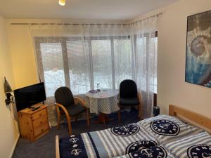 a bedroom with two beds and a table and chairs at Smans Fewo in Neustadt in Holstein