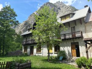 an old house with a mountain in the background at Chalet Hotel d Ailefroide in Ailefroide