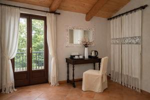 a room with a table and a chair and a window at LA CASA DI TALIN - Camere e appartamenti - Accoglienza adults only in Serravalle delle Langhe