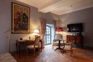 a living room with a desk and a table and chairs at Château de Collias - Maison de Vacances in Collias