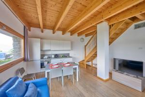 a kitchen and living room with a table and chairs at paradiso del lago t4 in Bellano