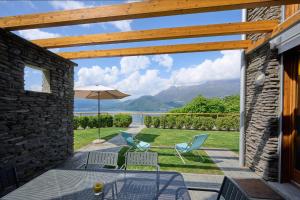 a patio with a table and two chairs and an umbrella at paradiso del lago t4 in Bellano