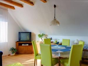 una sala da pranzo con tavolo, sedie e TV di Haus Wehrle a Breisach am Rhein