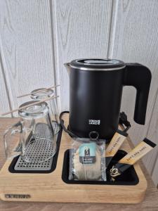 a slow cooker on a cutting board next to a blender at Cit'Hôtel Le Quai 9 in Challans