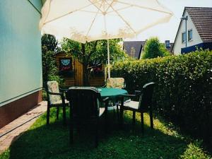 einen Tisch und Stühle unter einem Regenschirm im Hof in der Unterkunft Haus Wehrle in Breisach am Rhein