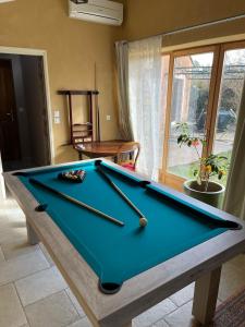 a pool table in a living room with a blue pool table at La Parenthèse ardéchoise - Spa et billard - Se ressourcer entre ville et forêt in Privas