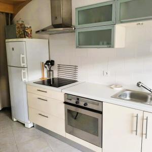 a kitchen with white appliances and a white refrigerator at L'Etalon, maison dans corps de ferme in Chailly-sur-Armançon